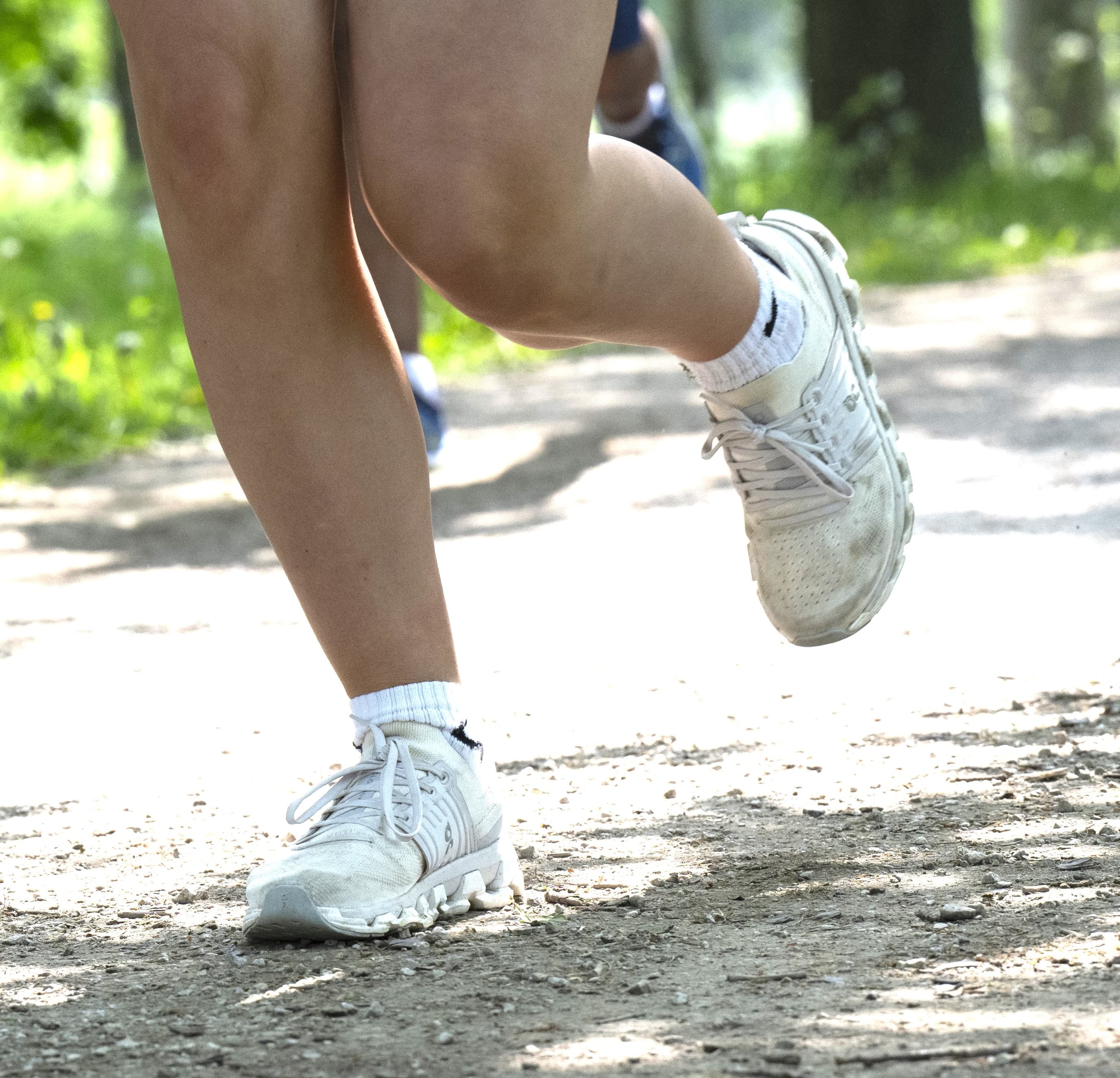 A person in running attire doing up their laces on their trainers.