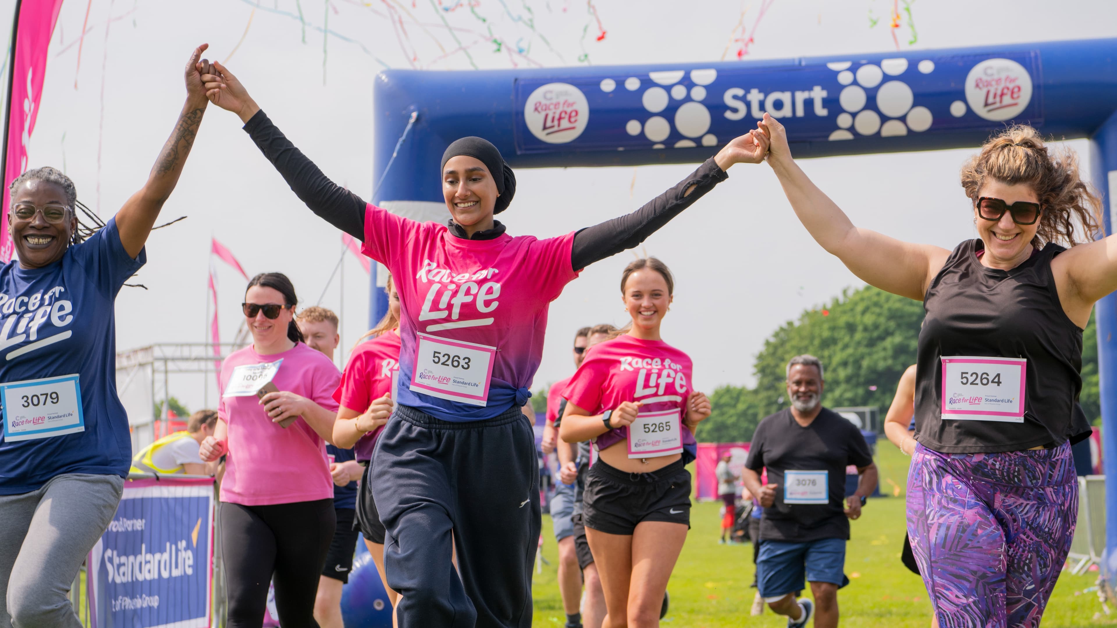 A group of people celebrating as they cross the finish line.